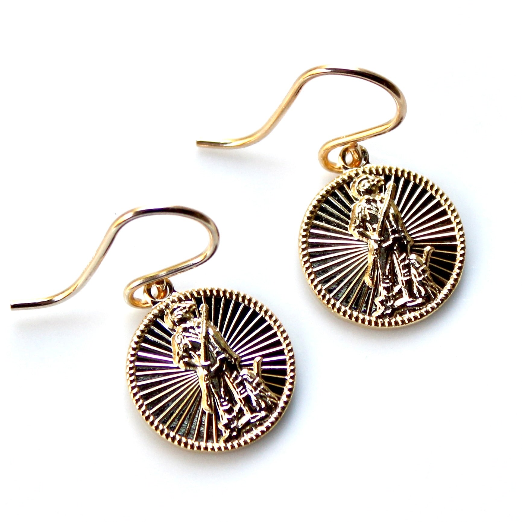 Gold and black earrings with intricate designs on a white background
