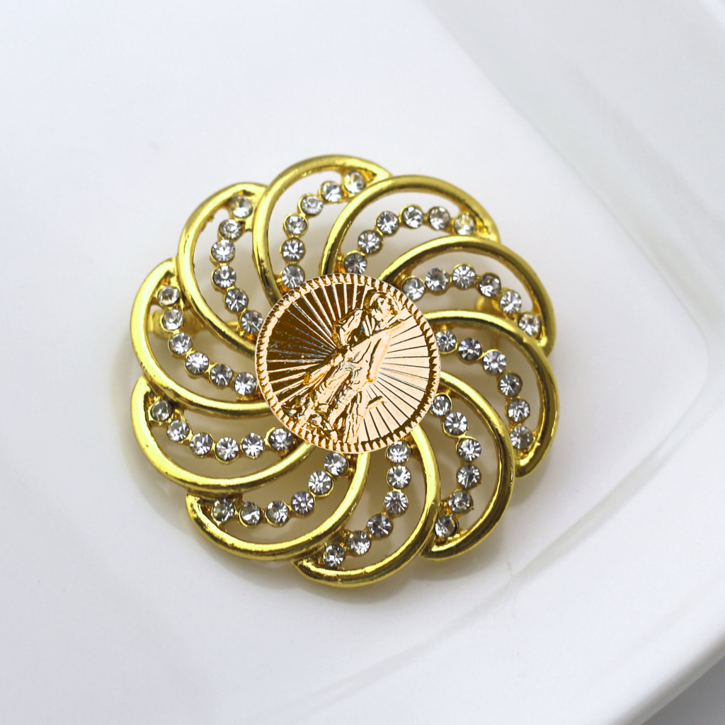 Gold brooch with National Guard design and gemstones on a white background