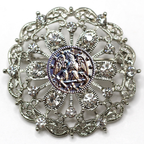 Decorative brooch with intricate design and central Navy inspired insignia on a white background
