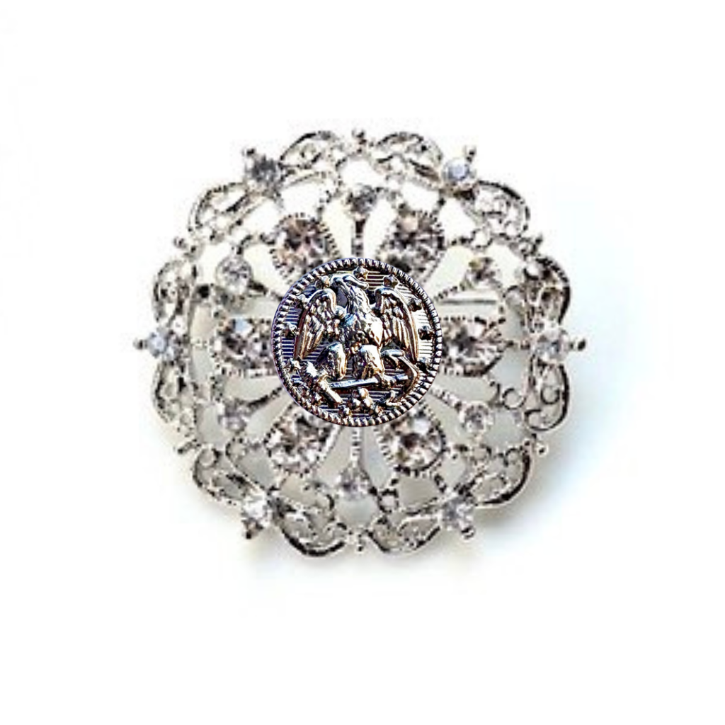 Decorative brooch with intricate design and central Navy inspired insginia on a white background