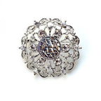 Decorative brooch with intricate design and central Navy inspired insginia on a white background