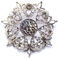 Decorative brooch with crystal-like stones on a white background