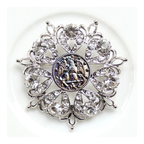 Decorative brooch with crystal-like elements on a white background