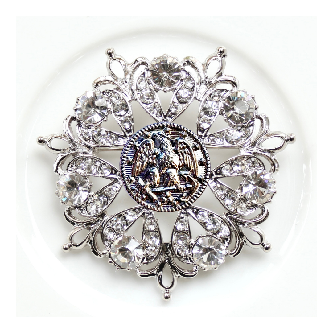 Decorative brooch with crystal-like elements on a white background