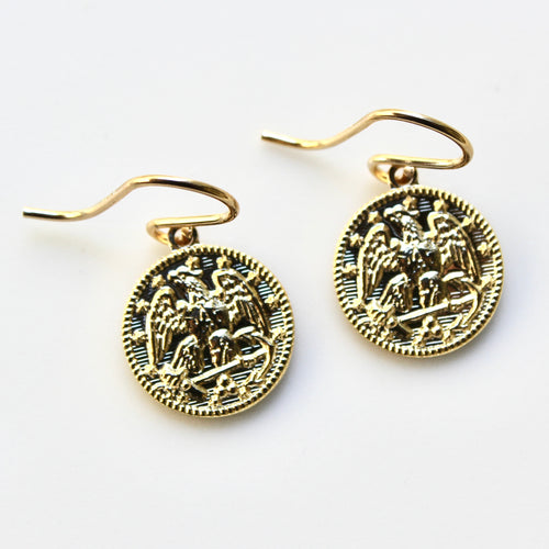 Gold earrings with intricate designs on a white background