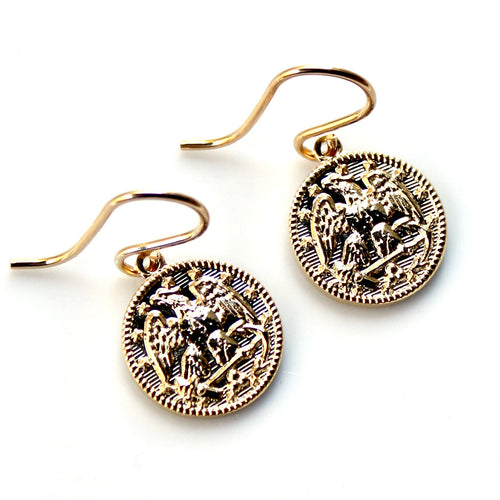 Gold coin-shaped earrings on a white background