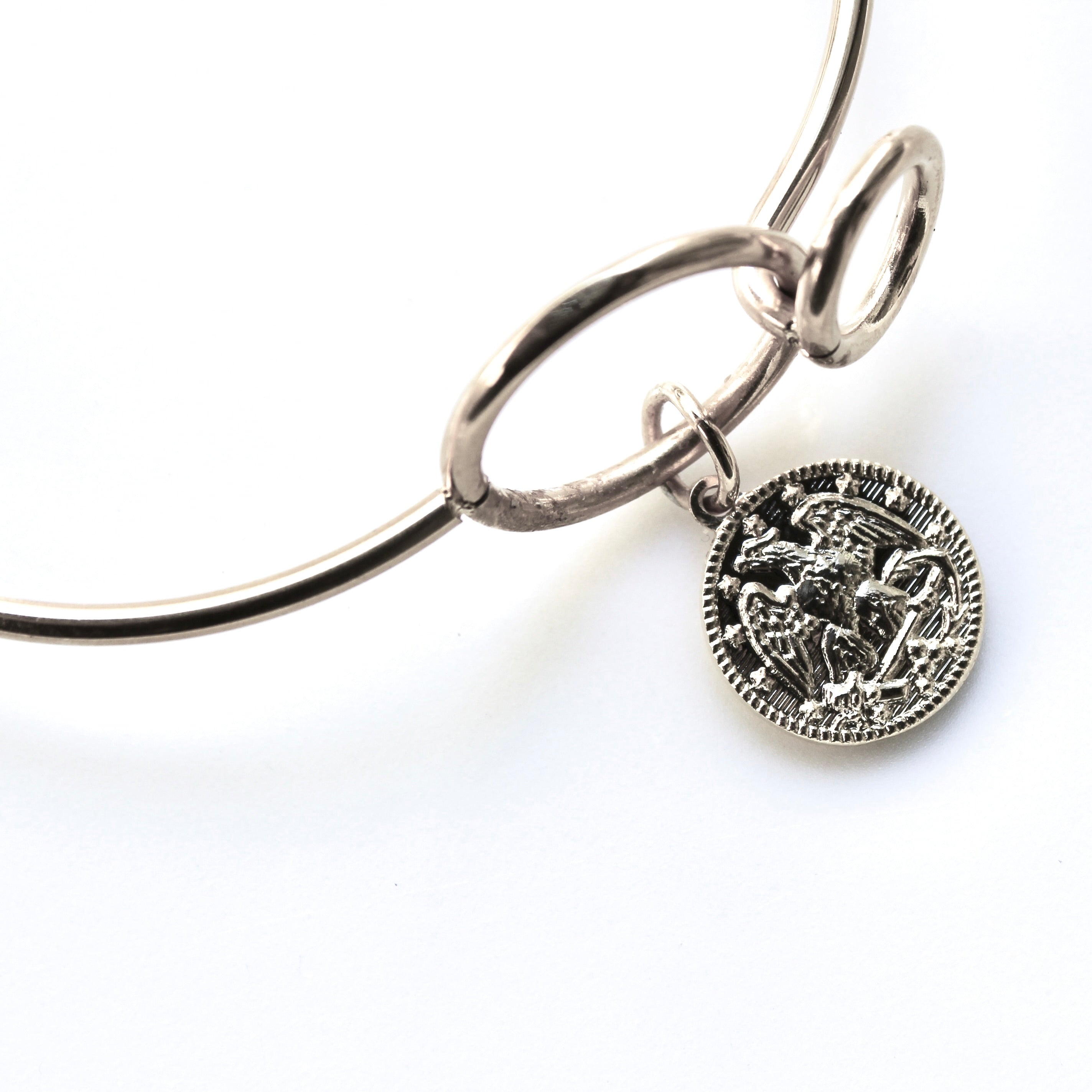 Silver bracelet with a detailed pendant on a white background