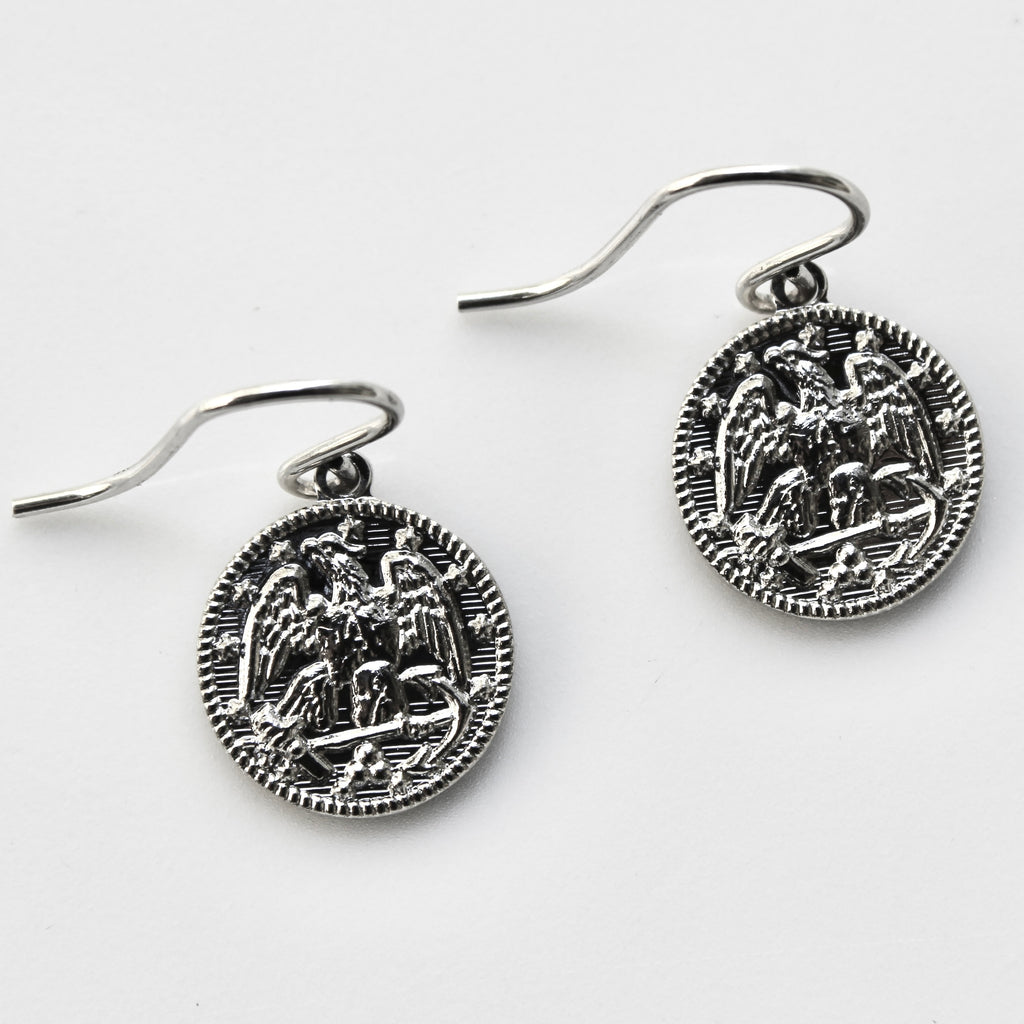 Pair of silver earrings with intricate designs on a white background