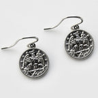 Pair of silver earrings with intricate designs on a white background