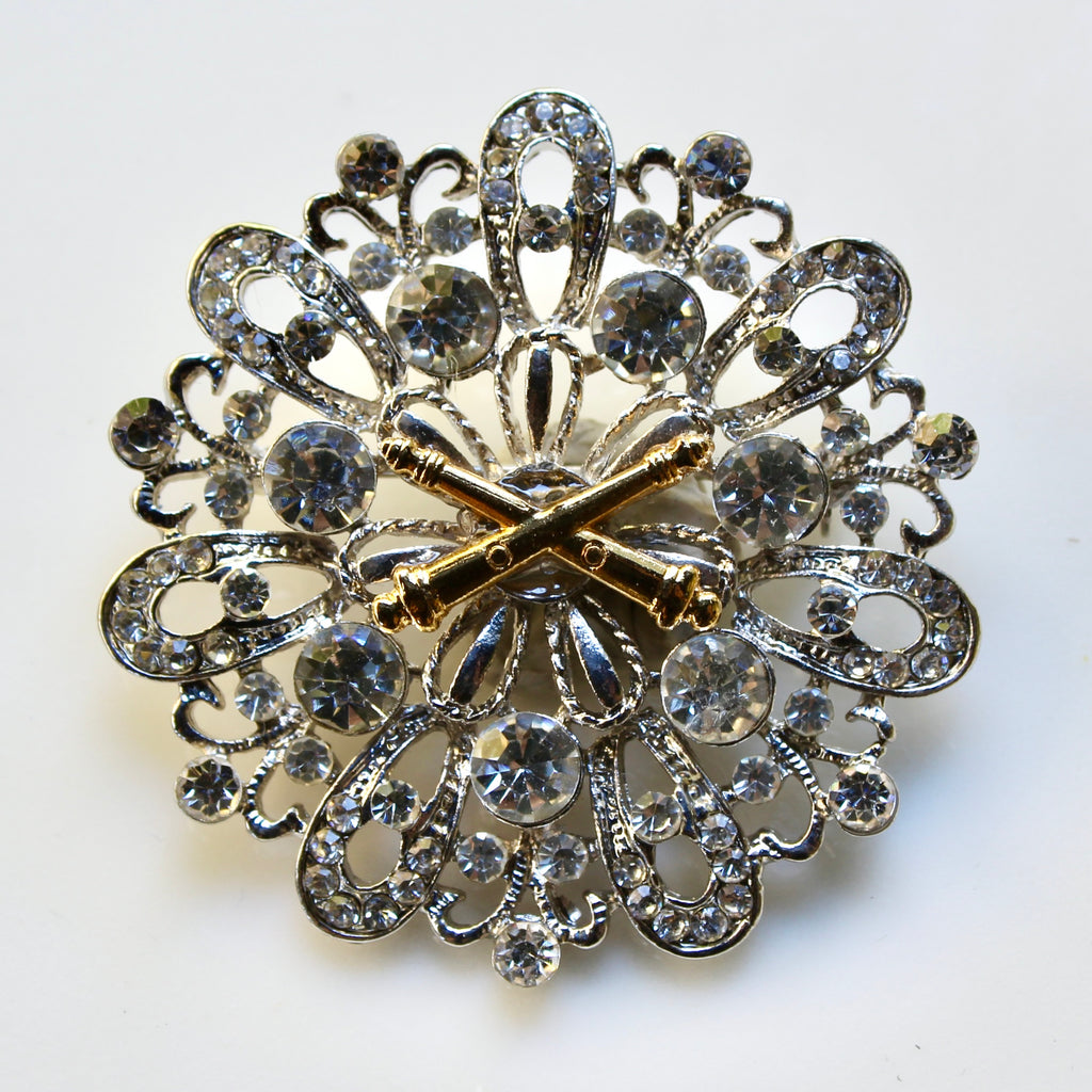 Decorative brooch with intricate design and gold accents on a white background
