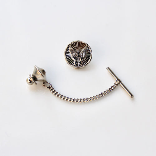 Silver tie pin with chain and eagle emblem on a white background