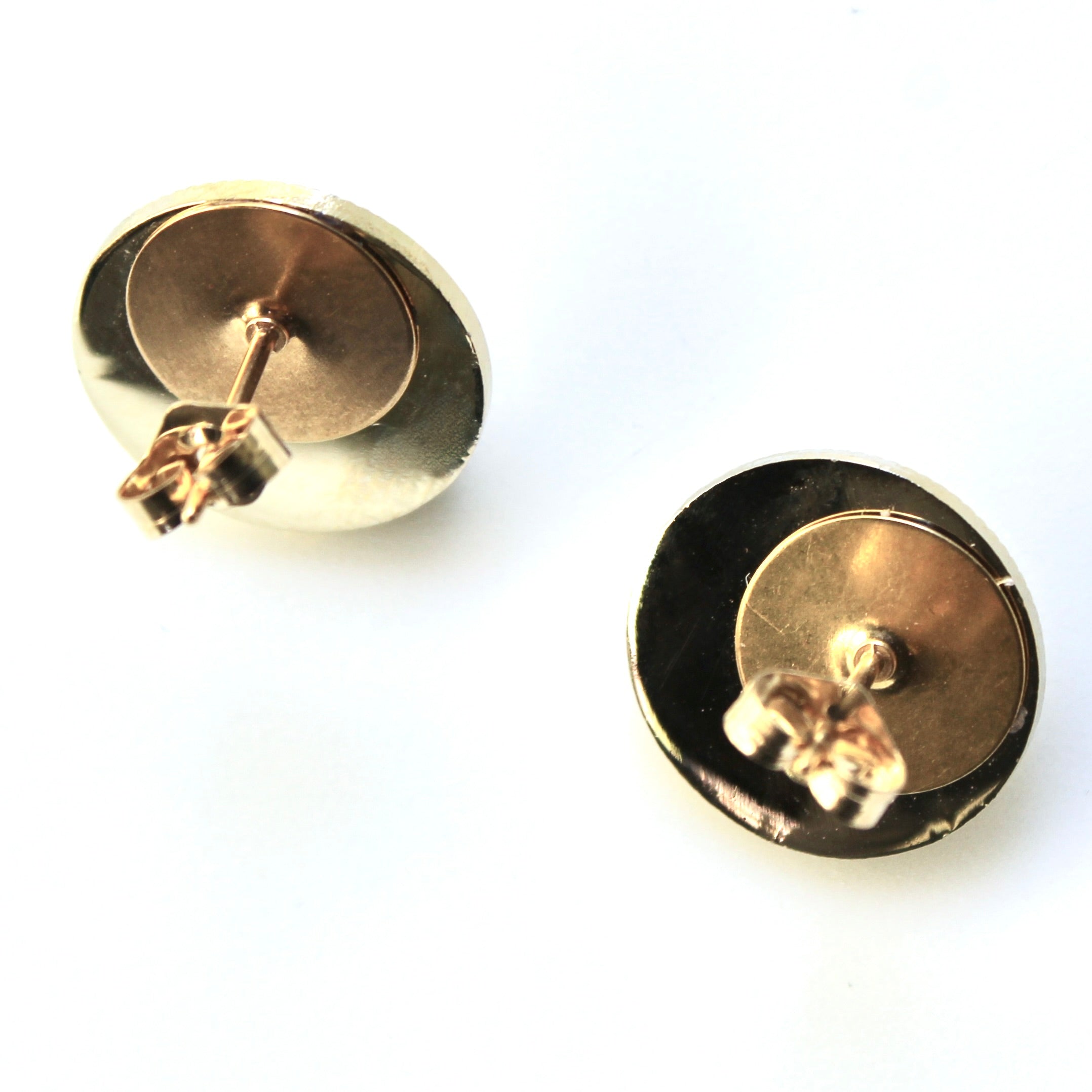 Gold stud earrings on a white background