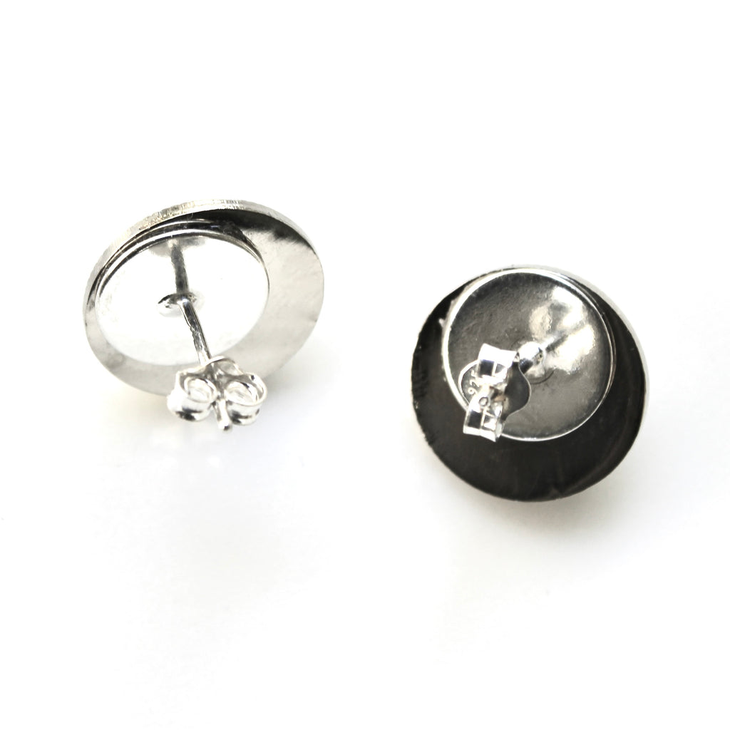 Silver earring with black back on a white background
