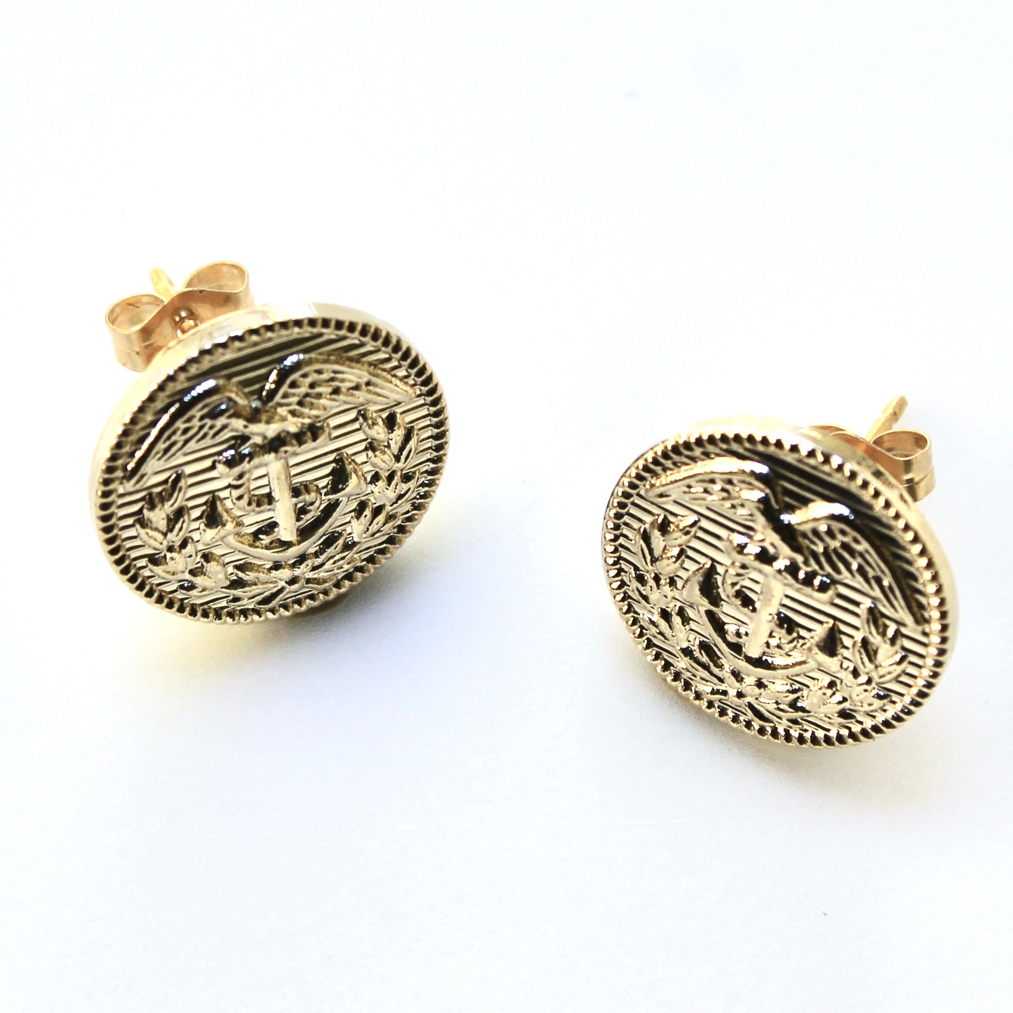 Gold earrings with intricate designs on a white background