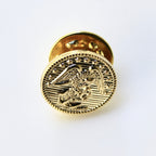 Gold-colored lapel pin with an eagle design on a white background