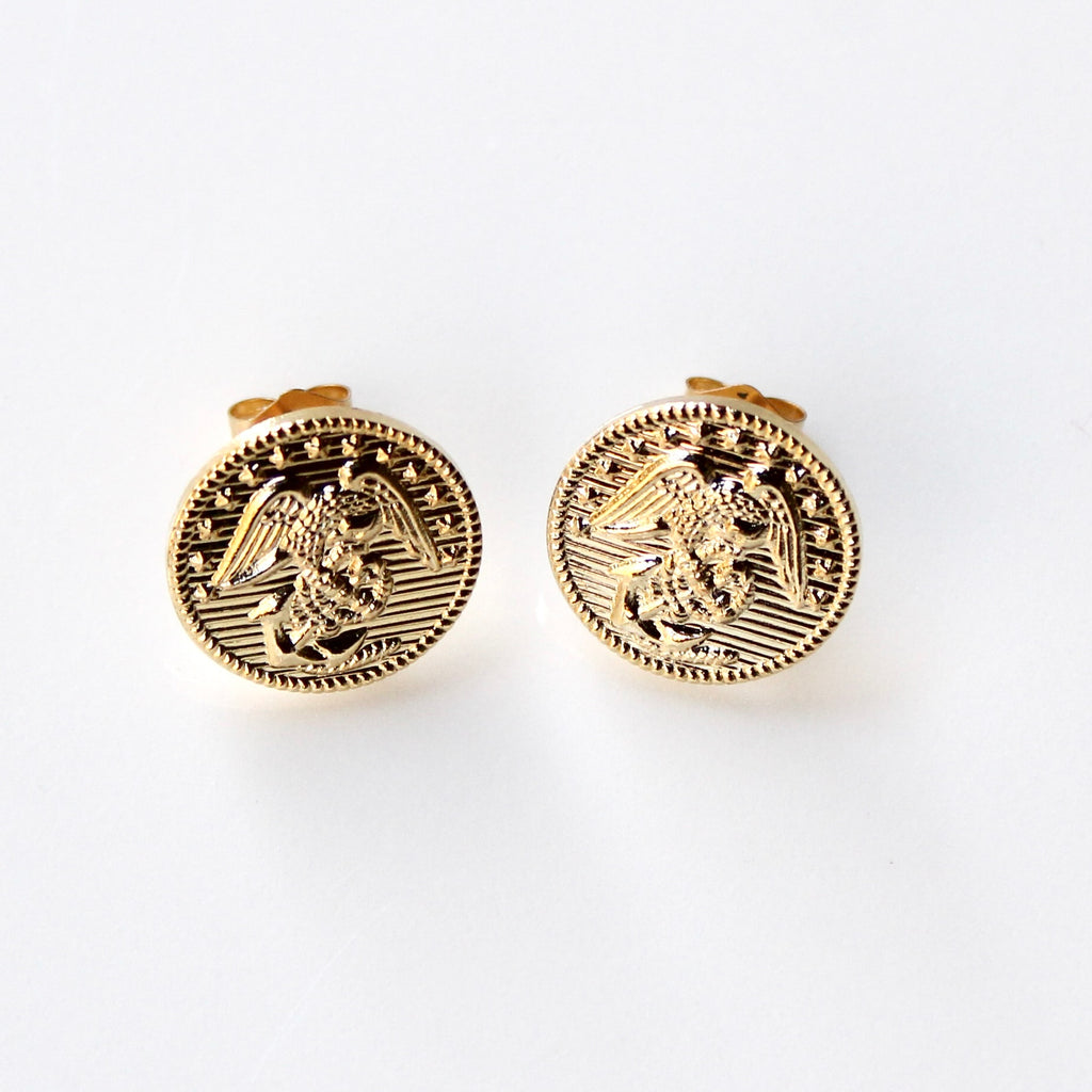 Gold circular earrings with an eagle design on a white background