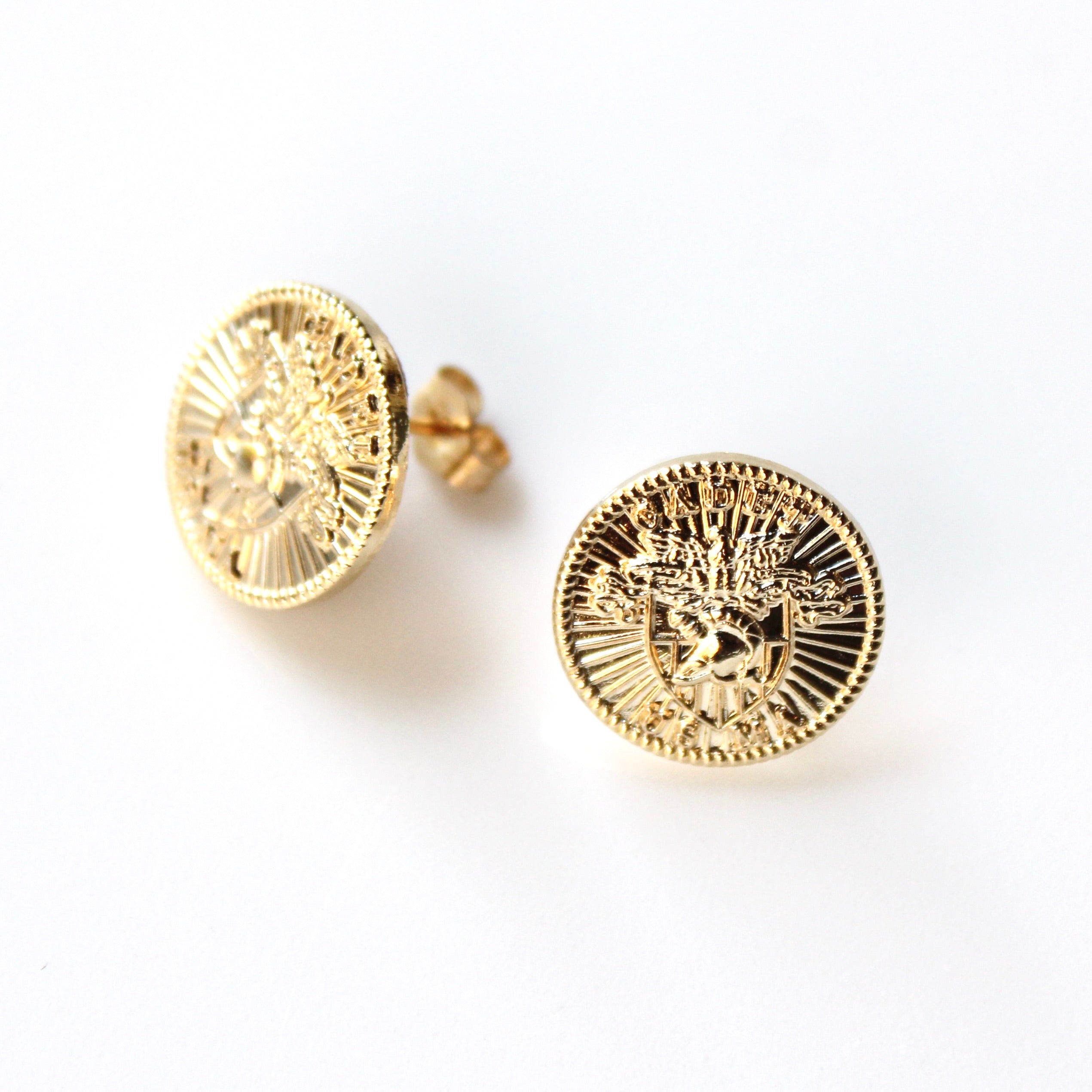 Gold circular earrings on a white background