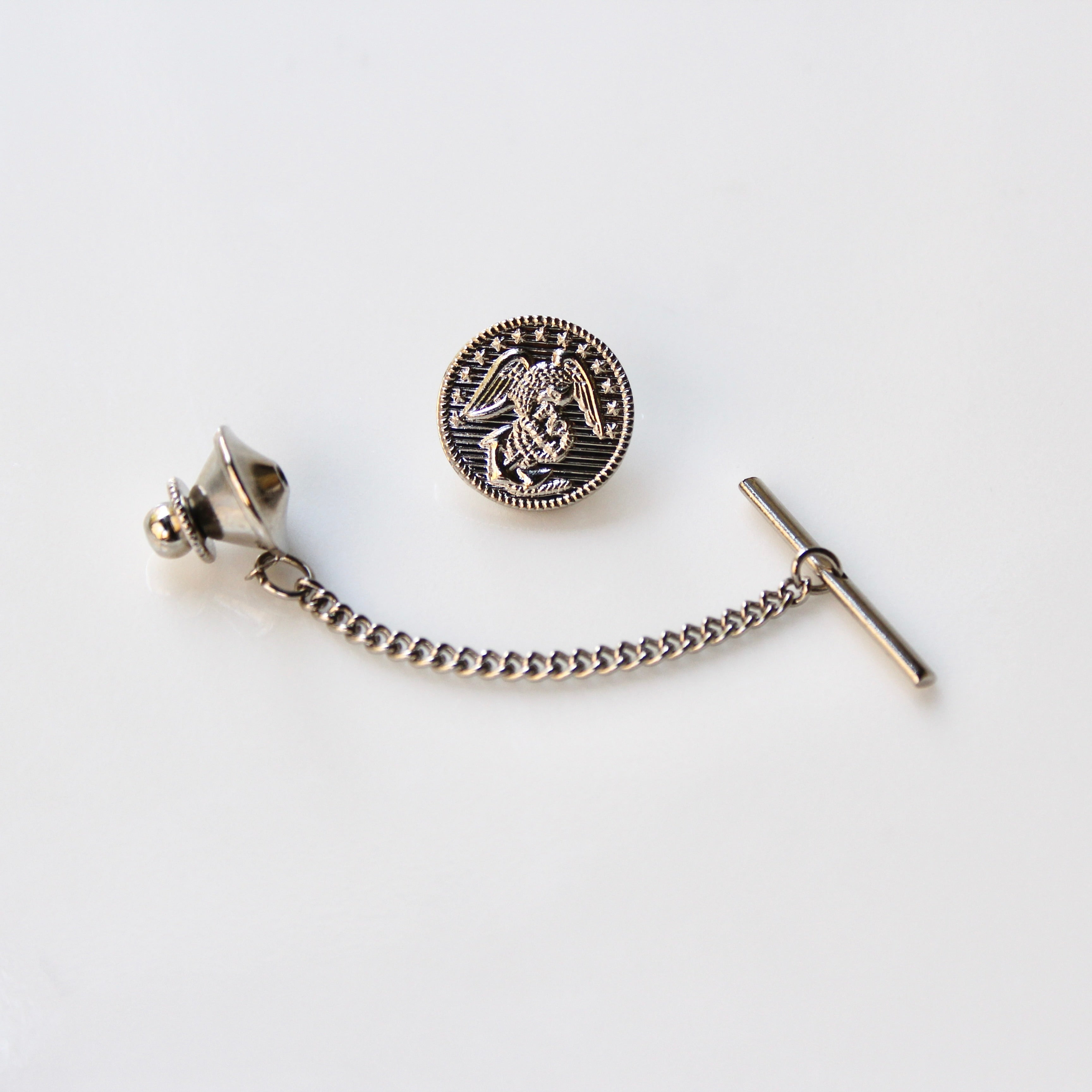 Silver tie pin with chain on a white background
