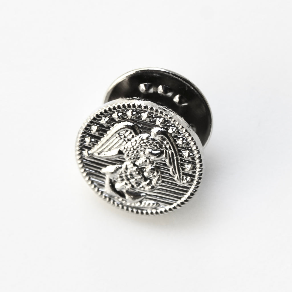 Silver metal button with eagle design on a white background
