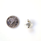 Silver button with intricate design on a white background