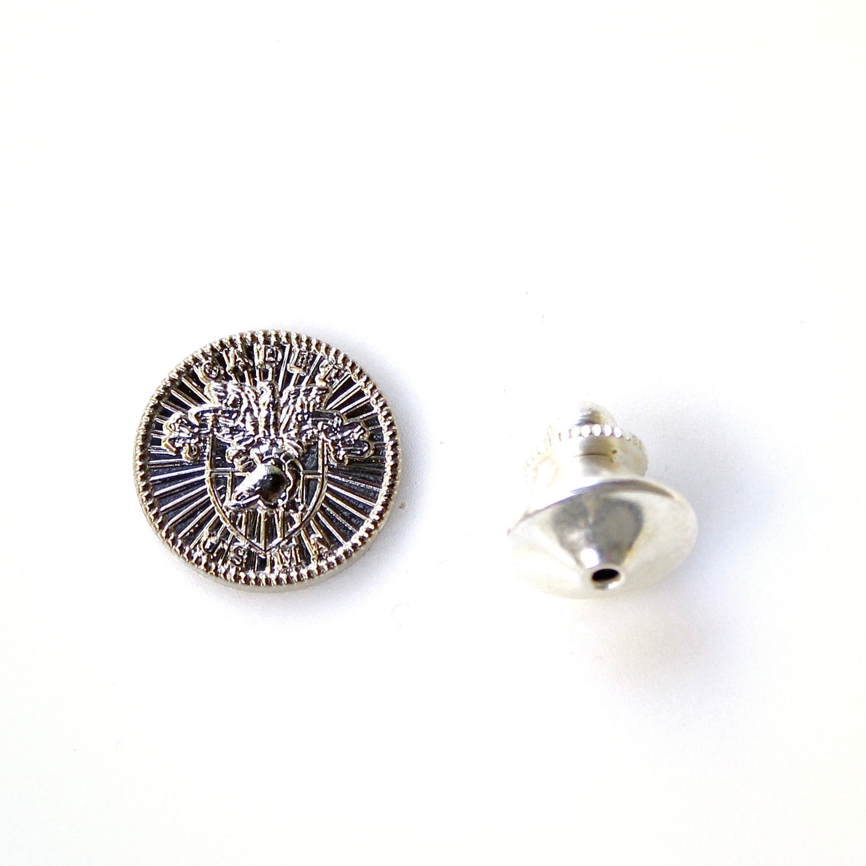 Silver button with intricate design on a white background