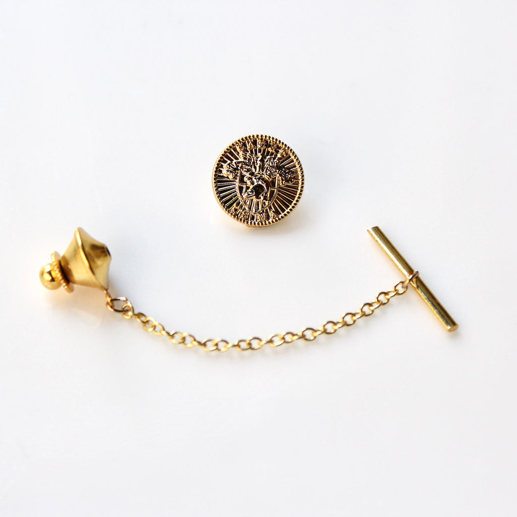 Gold tie pin with chain on a white background