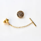 Gold tie pin with chain on a white background