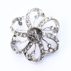 Silver flower-shaped brooch with clear gemstones and Space Force centerpiece on a white background