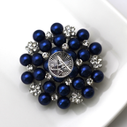 Brooch with blue pearls and silver accents on a white background