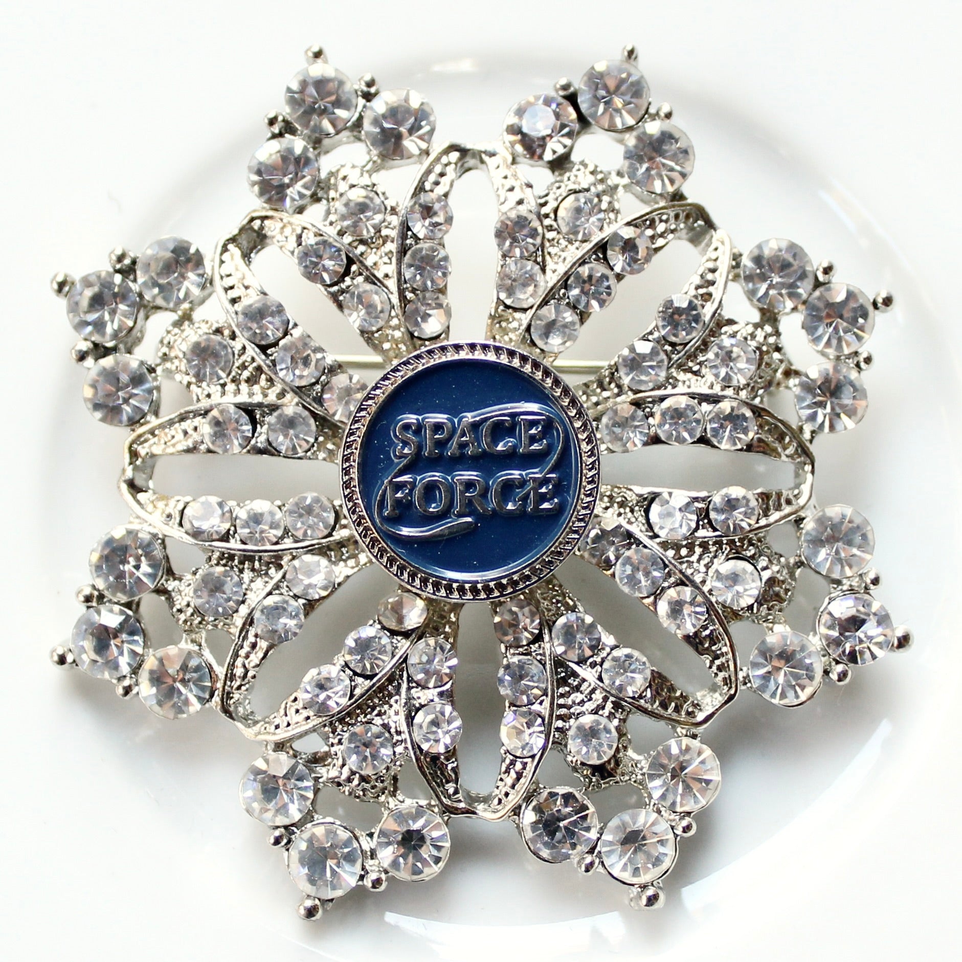 Decorative brooch with 'Space Force' emblem on a white background