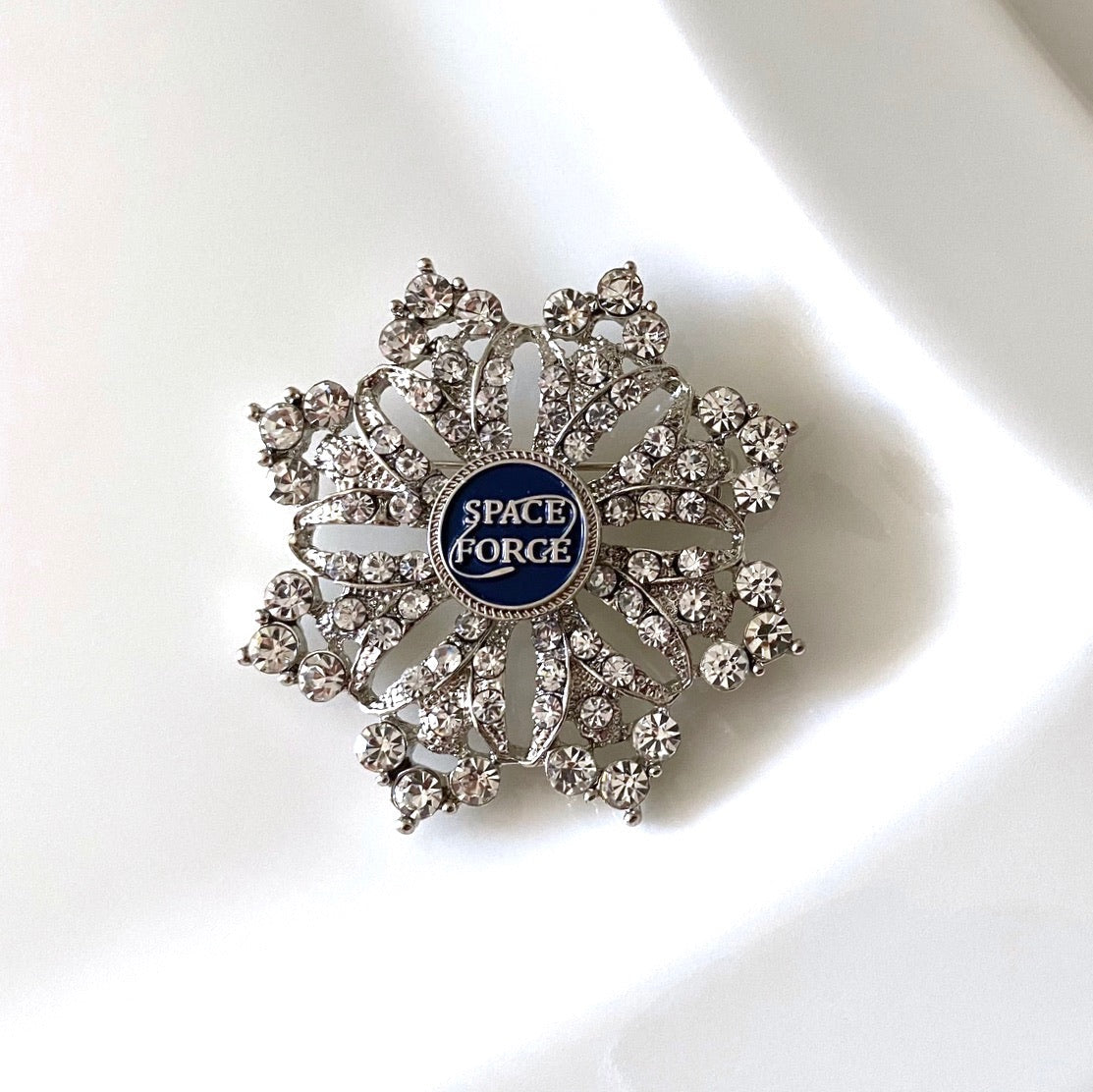 Decorative brooch with 'Space Force' emblem on a white background
