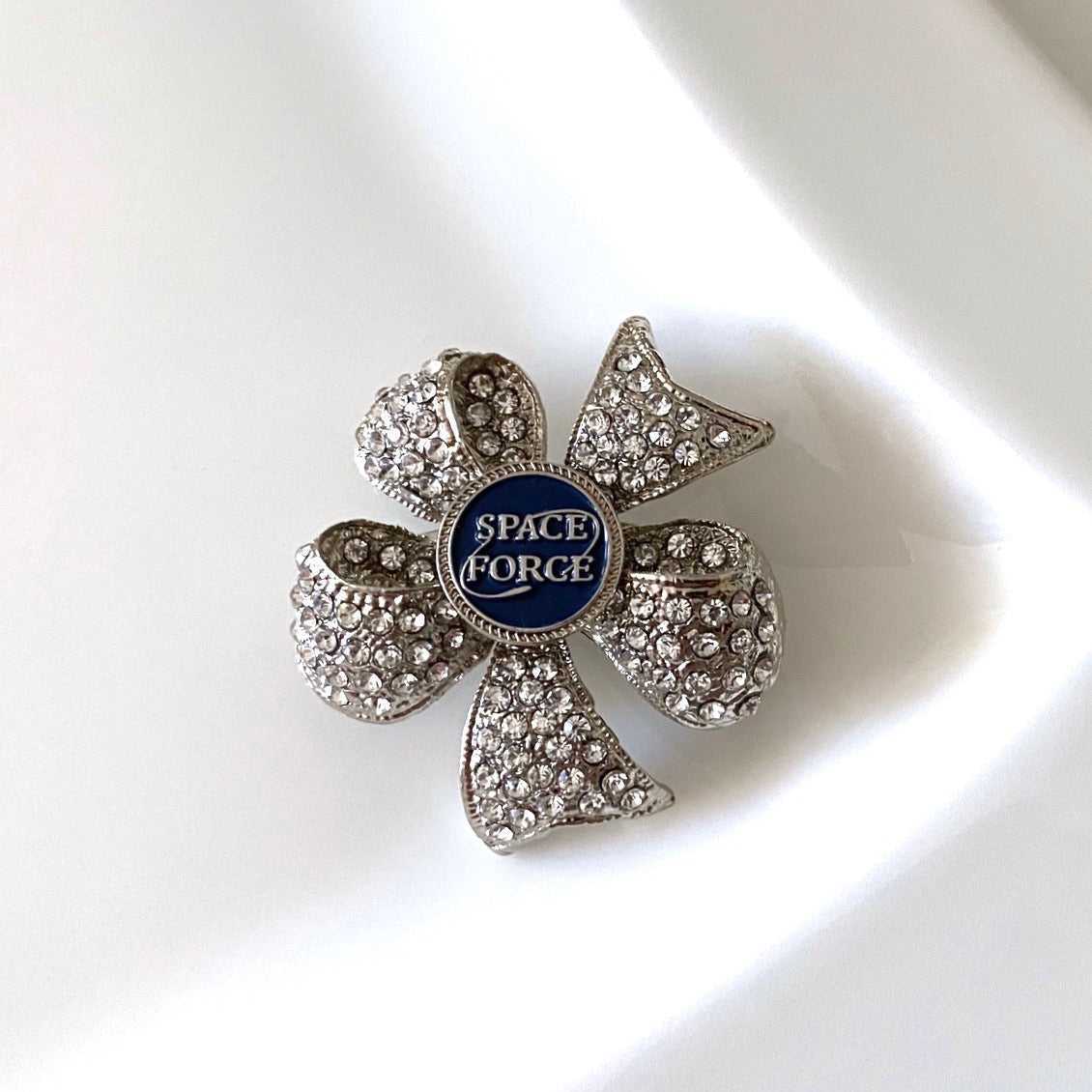 Decorative brooch with 'Space Force' emblem on a white surface
