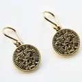 Gold earrings with intricate designs on a white background