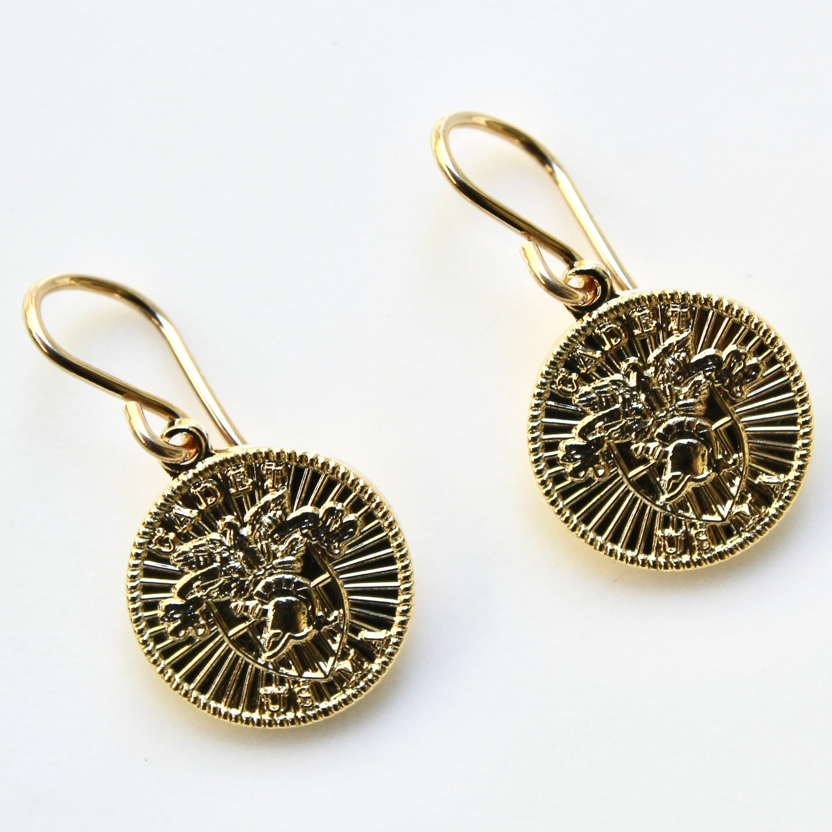 Gold earrings with intricate designs on a white background