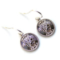 Silver earrings with intricate designs on a white background