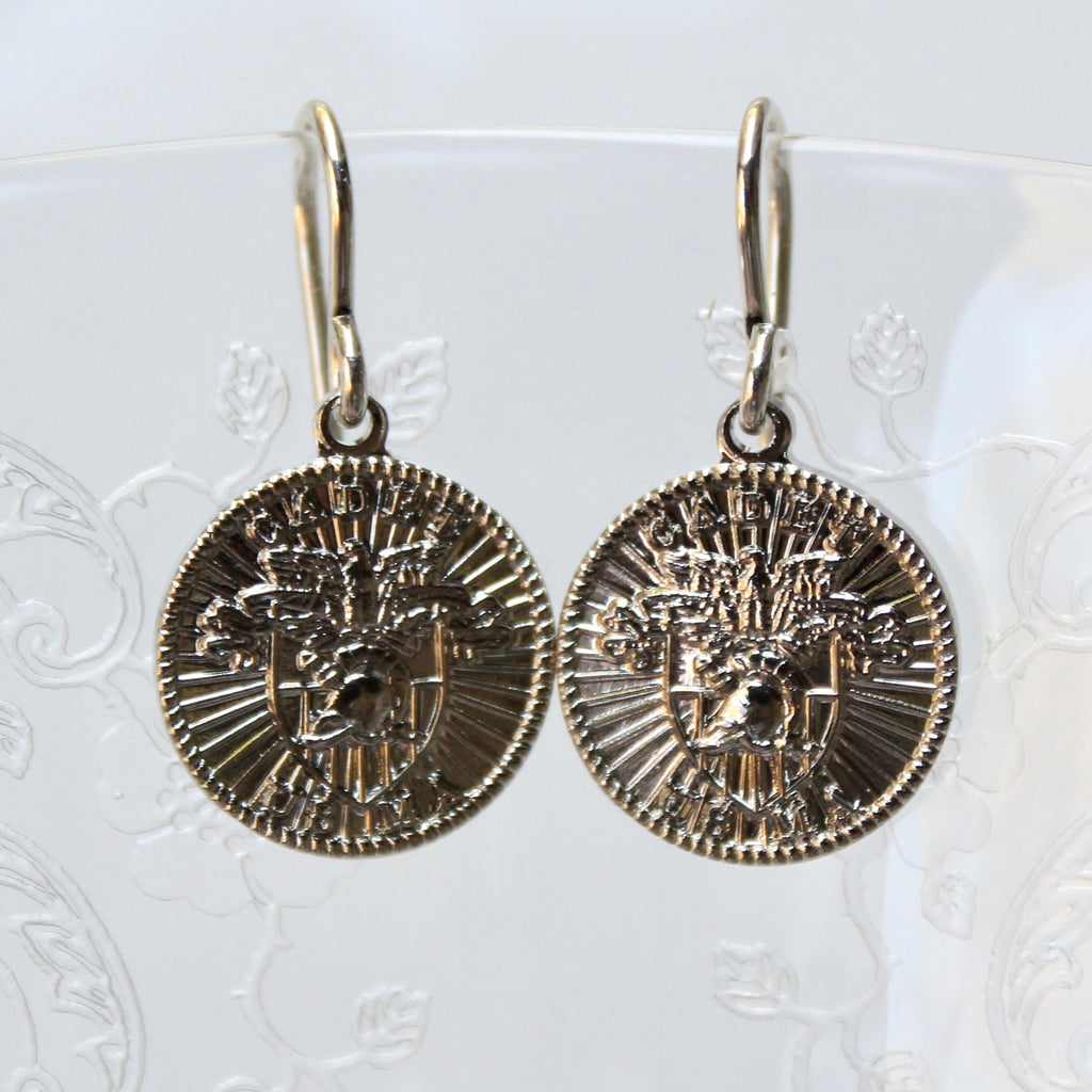 Pair of gold coin-shaped earrings on a white background