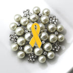 Pearl brooch with a yellow ribbon on a white background