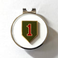 A golf hat clip with a magnetic ball marker featuring the 1st Infantry Division insignia, consisting of a red '1' on an olive drab shield, set against a white background.