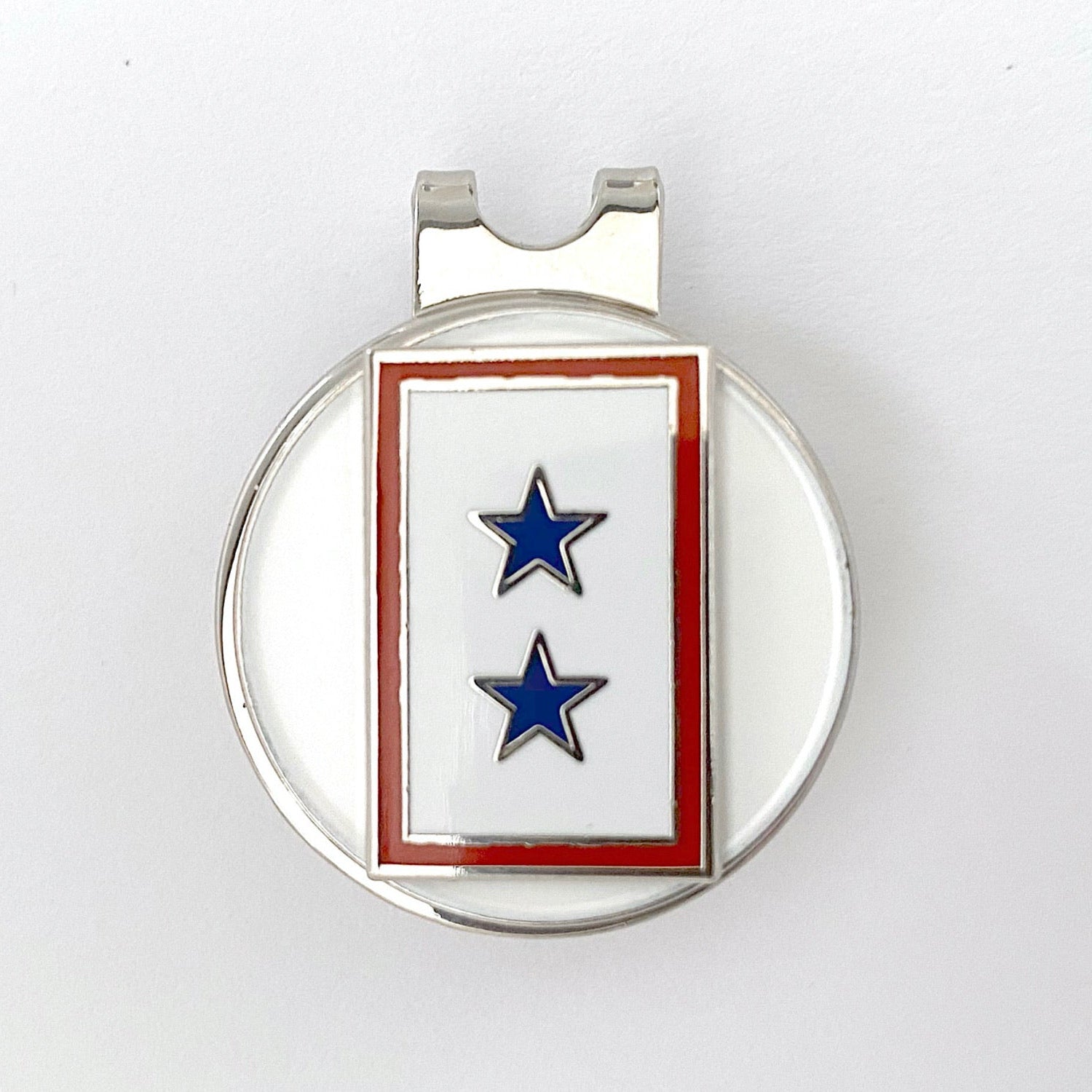 A golf hat clip featuring a blue star pattern, likely made of metal, with a round base designed to attach to a golf hat.