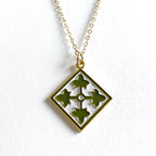 A gold-plated brass 4th Infantry Division charm necklace with a silver-tone steel chain.