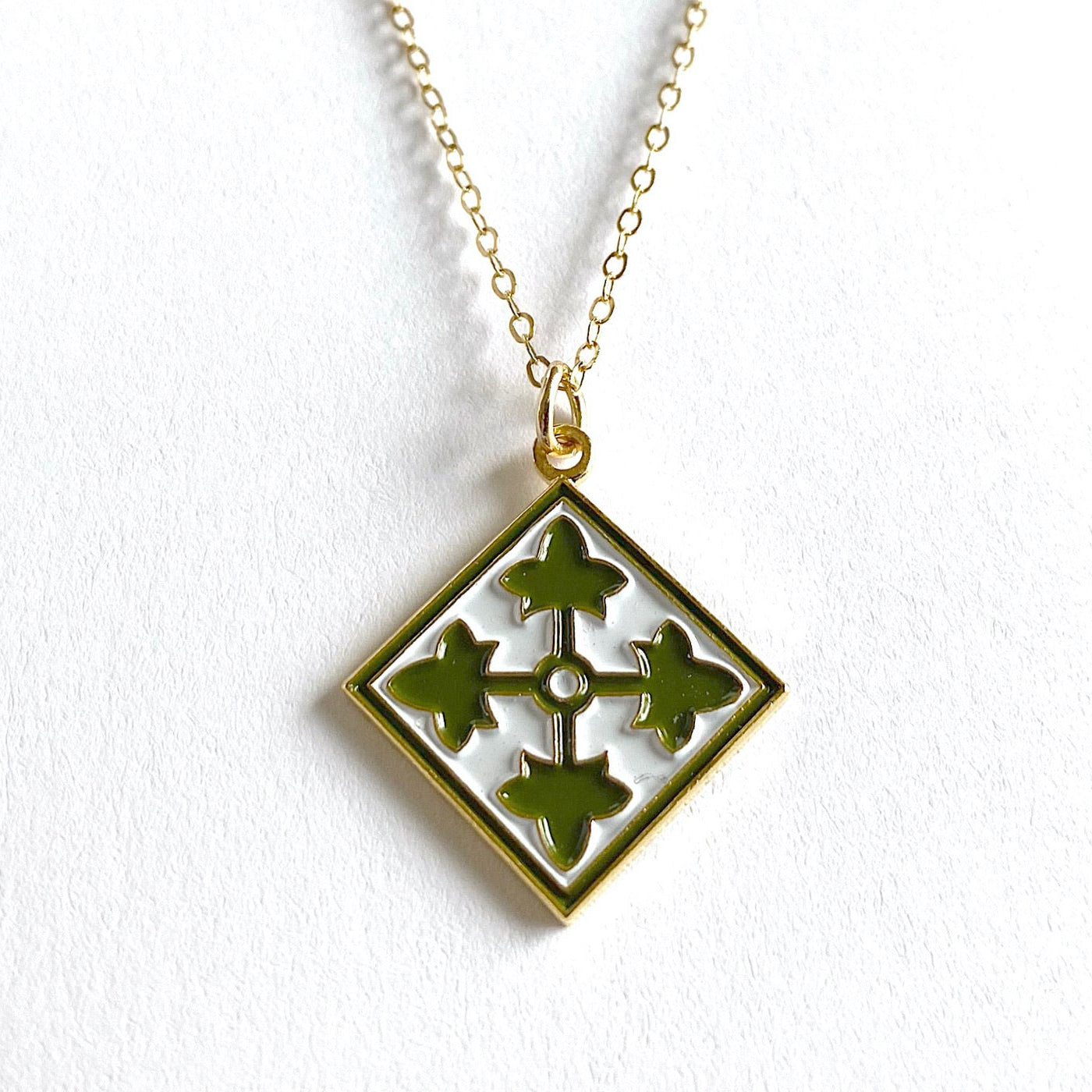 A gold-plated brass 4th Infantry Division charm necklace with a silver-tone steel chain.