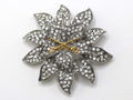 A silver brooch with a US Army Cavalry branch insignia, featuring two gold crossed sabers in scabbards with the cutting edge facing up, set against a clear, star-shaped background with embellishments.