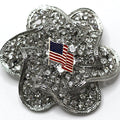 A silver brooch with a American flag centerpiece and crystal rhinestones.