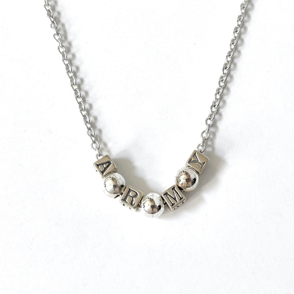 Silver necklace with letter beads on a white background