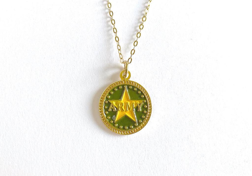 A gold-colored necklace featuring a round charm with the word 'ARMY' in the center, displayed on a white background.