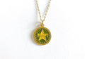 A gold-colored necklace featuring a round charm with the word 'ARMY' in the center, displayed on a white background.