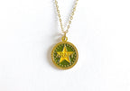A gold-colored necklace featuring a round charm with the word 'ARMY' in the center, displayed on a white background.