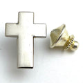 A silver-colored metal cross lapel pin with a gold-colored metal clasp.