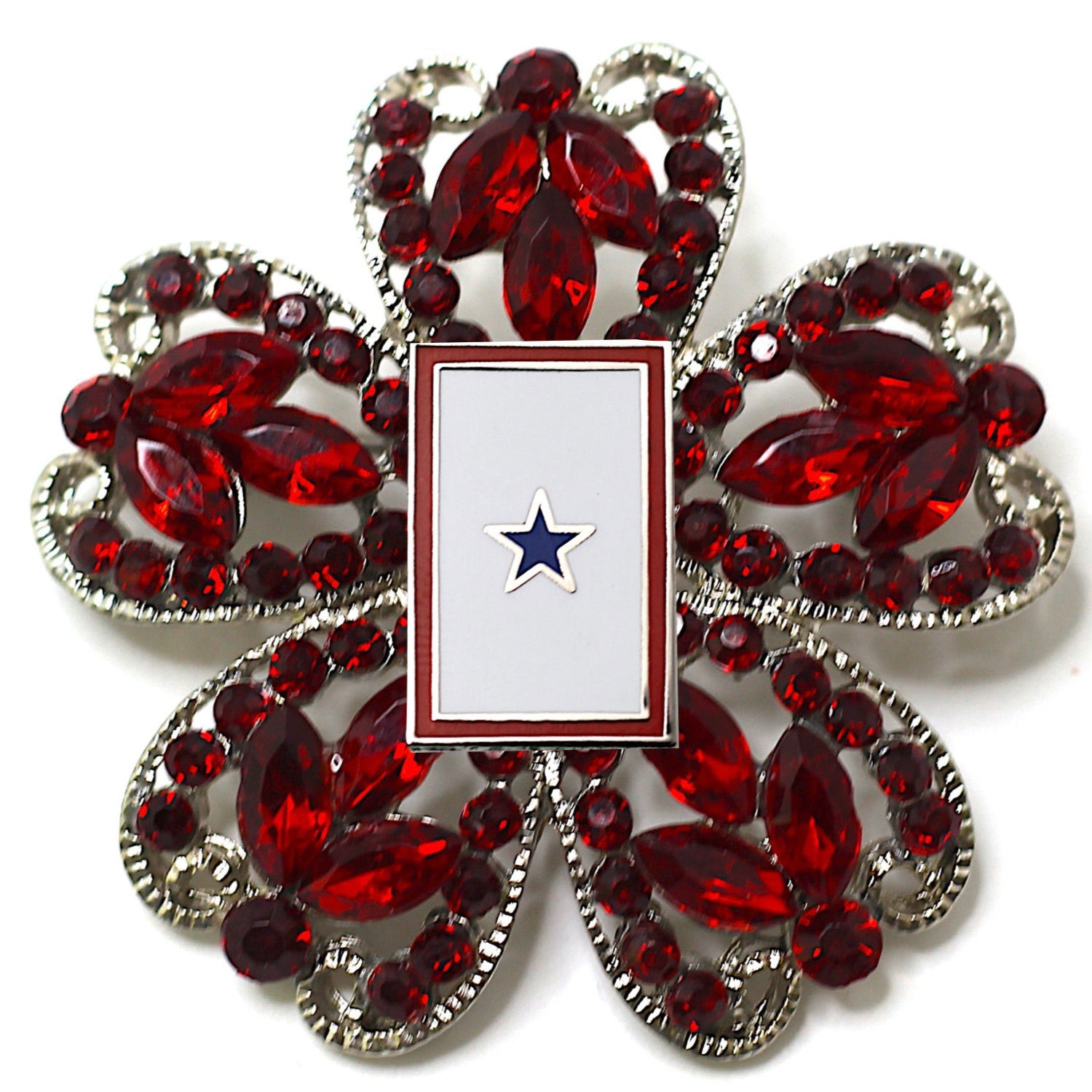 A brooch with a central blue star surrounded by red crystal rhinestones, with a silver-colored design.