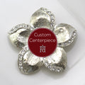 A silver brooch with clear crystals designed in a floral pattern, featuring a custom center piece with the text 'Custom Centerpiece' and the Hope Design Ltd. logo.